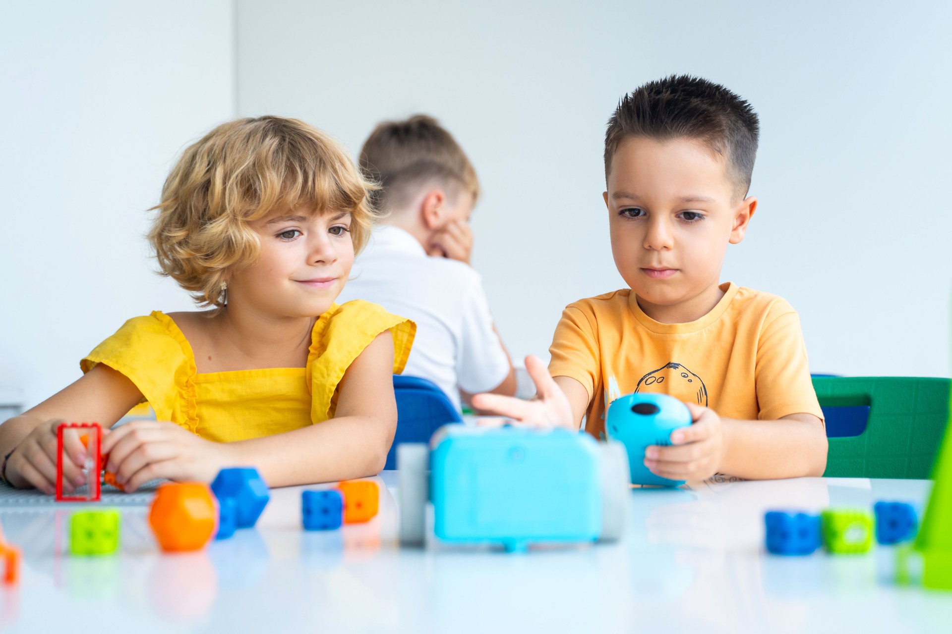 Robotics programming class. Preschool Children construct and code Robot. STEM education using constructor blocks and laptop, remote control joystick. Technology educational development for school kids.